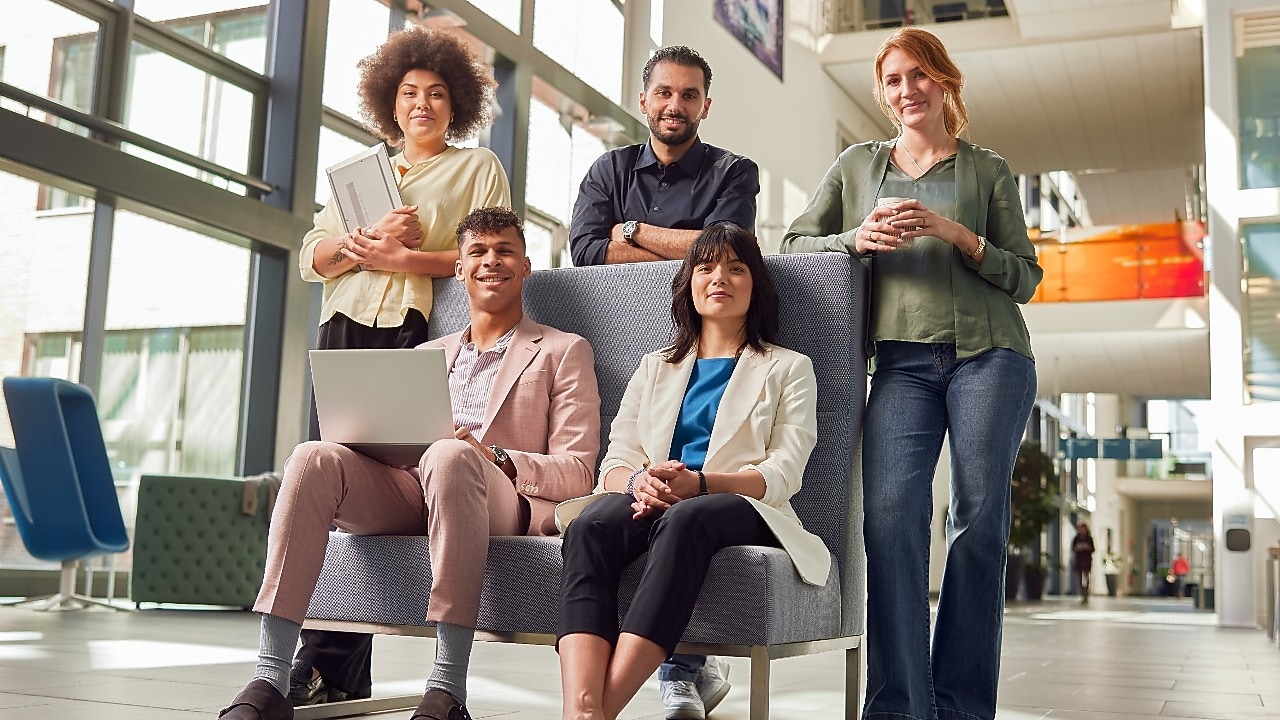 Fünf Mitarbeiter in einer hellen und modernen Büroumgebung