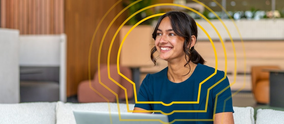 Person arbeitet mit einem Laptop in einer modernen, offenen Sitzlounge