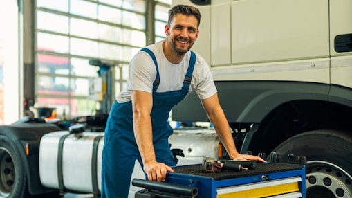 Mechaniker arbeitet an einem Werkstattwagen neben einem Lastwagen