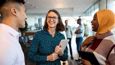 Drei Kollegen unterhalten sich in einem Büro