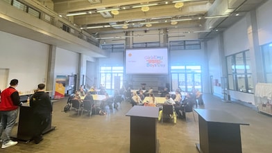 Innenaufnahme einer großen Halle mit Jugendlichen an Gruppentischen; auf der Leinwand steht „Girls’ Day & Boys’ Day“ als Teil der Eröffnungsveranstaltung.