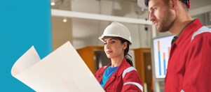 Zwei Profis in Sicherheitskleidung schauen sich Pläne an.