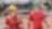Two workers in red overalls walking in an industrial environment 
