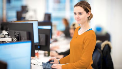 Person arbeitet an einem Computer in einem modernen Büro