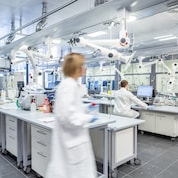 Ein modernes Labor mit weiß gekleideten Wissenschaftlern bei der Arbeit.