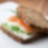 Vollkornsandwich mit geräuchertem Lachs, geschnittenem Ei und frischem Schnittlauch auf Frischkäse.