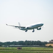 Ein großes weißes Flugzeug hebt von einer Startbahn ab.