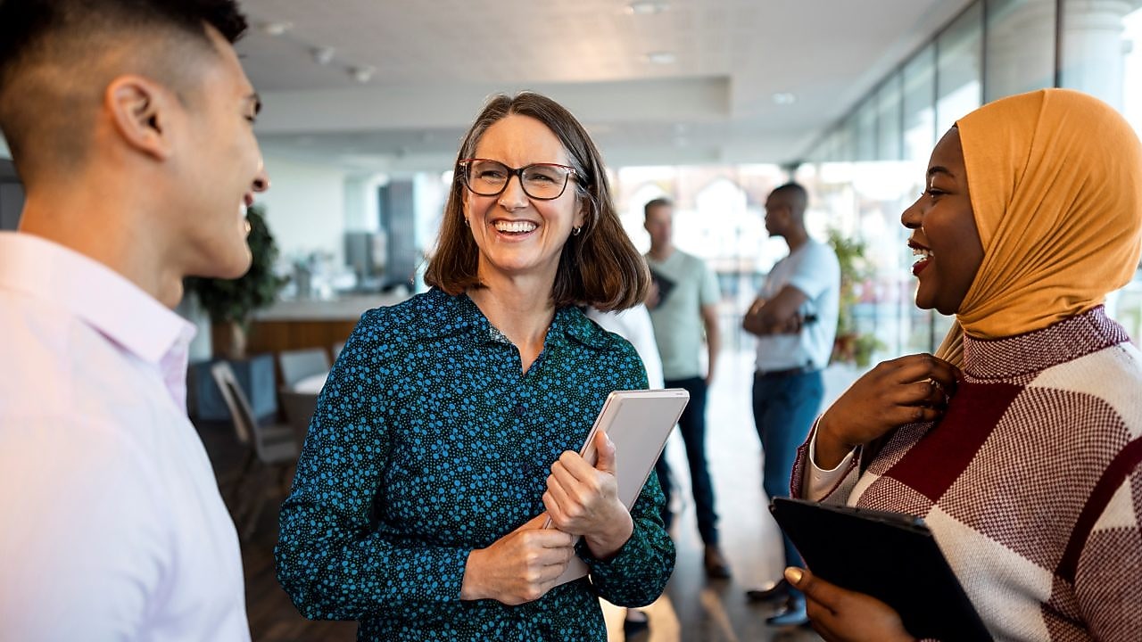 Drei Kollegen unterhalten sich in einem Büro