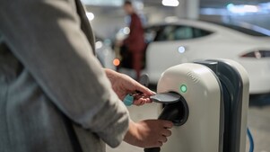 Vater und Tochter mit Elektrofahrzeug an Shell Station