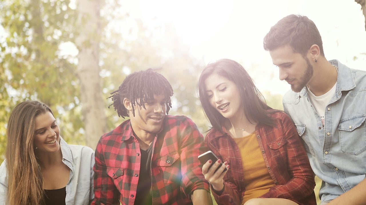 Drei Jugendliche, die fröhlich miteinander kommunizieren