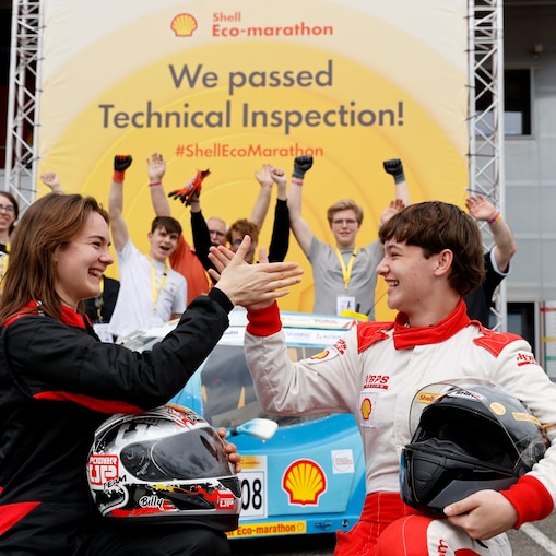 Fahrer und Coach unterhalten am Fahrzeug bei Teilnahme am Eco-marathon