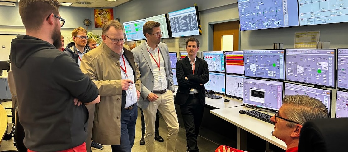 Besuch des Kölner Oberbügermeisters Torsten Burmester in ekiner Messwarte des Shell Energy and Chemicals Park Rheinland: Im Gespräch mit Mitarbeitenden vor mehreren Überwachungs- und Steuerungsmonitoren. 