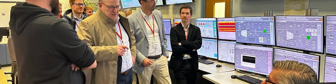 Besuch des Kölner Oberbügermeisters Torsten Burmester in ekiner Messwarte des Shell Energy and Chemicals Park Rheinland: Im Gespräch mit Mitarbeitenden vor mehreren Überwachungs- und Steuerungsmonitoren. 