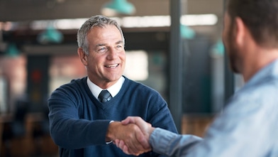 Ein Mann in einem Auto schaut in den Rückspiegel