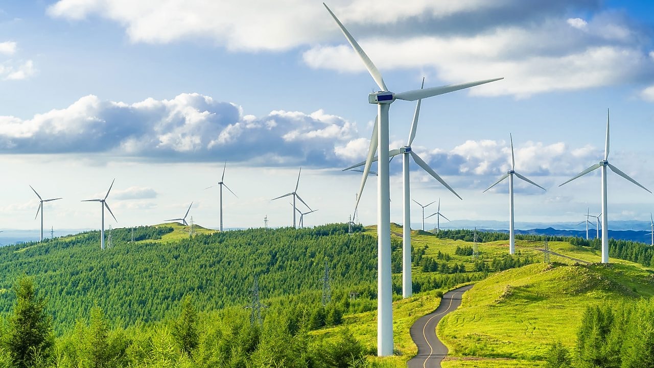 Windräder auf einem grünen Hügel