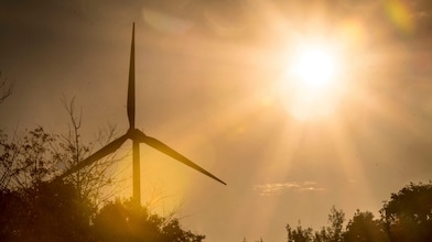 Ein Windrad steht in der Sonne.