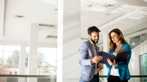 Eine Frau und ein Mann unterhalten sich über eine Mappe