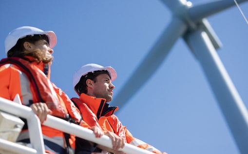 2 Arbeiter stehen unter einem Windrad