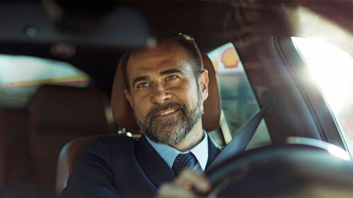 Ein Mann in einem Auto schaut in den Rückspiegel