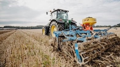 Traktor fährt über das Feld