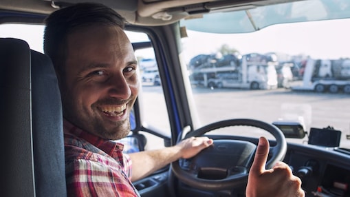 Freundlicher LKW Fahrer guckt in die Kamera