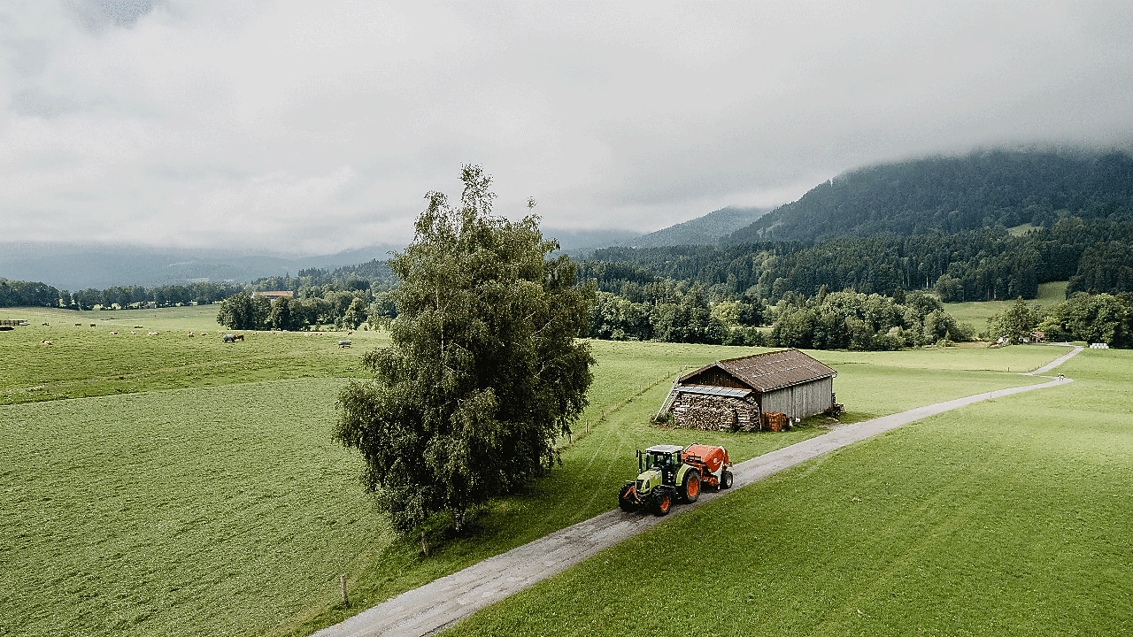 Traktor fährt durch Berglandschaft