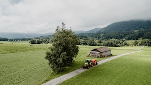 Traktor fährt durch Berglandschaft