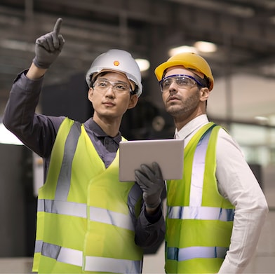 Shell Mitarbeiter berät einen Industriearbeiter vor Ort