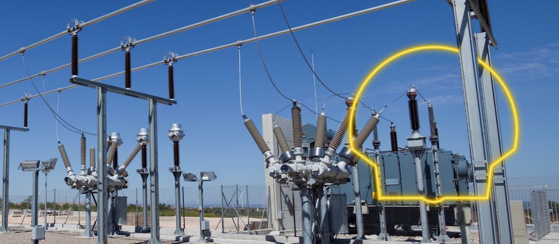 A photograph of a transformer with the sun rising behind it.