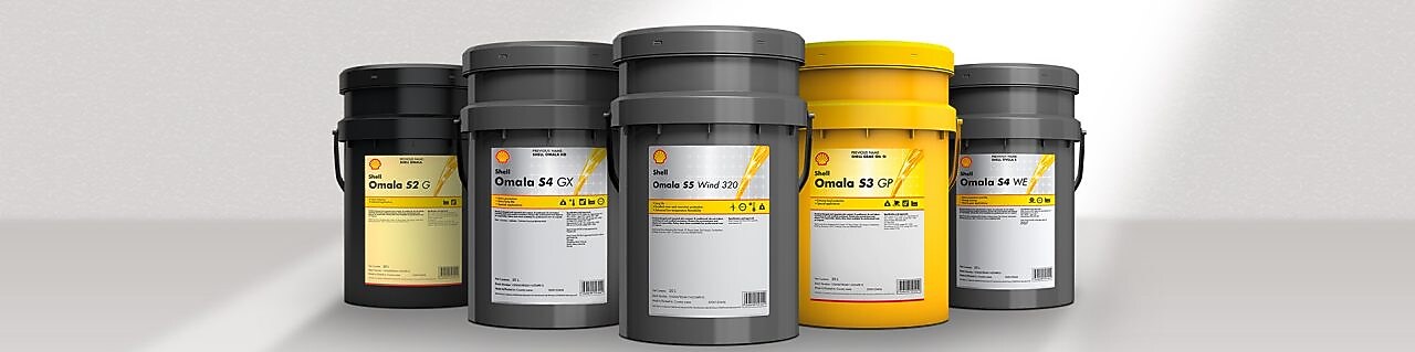 Industrielle Wartung eines großen Zahnradgetriebes in einer Produktionshalle, präzise Schmierung und Maschinenpflege.