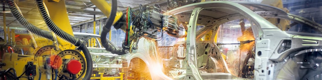 Automatisierte Automobil-Produktionslinie mit Schweißrobotern und Funken in einer Industrieanlage für Präzisionstechnik und Schmierstoffleistung