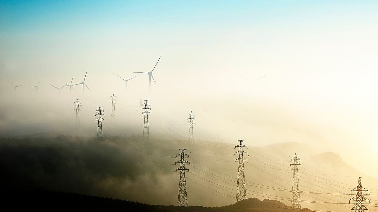 Stromerzeugende Windmühlen und Strommasten