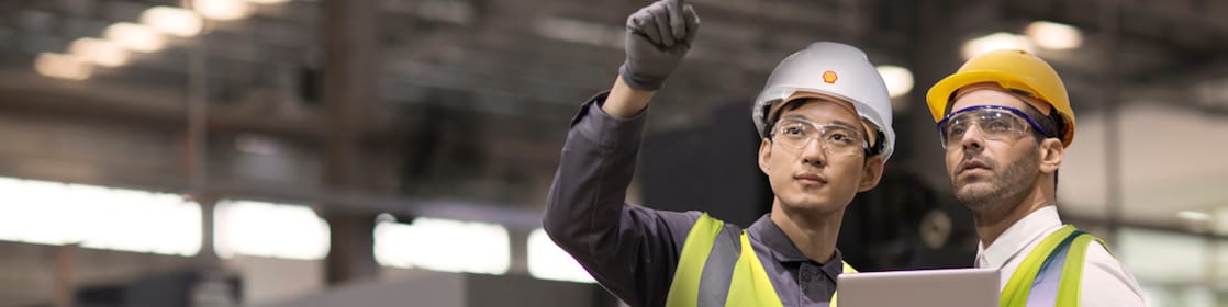 Shell Mitarbeiter berät einen Industriearbeiter vor Ort