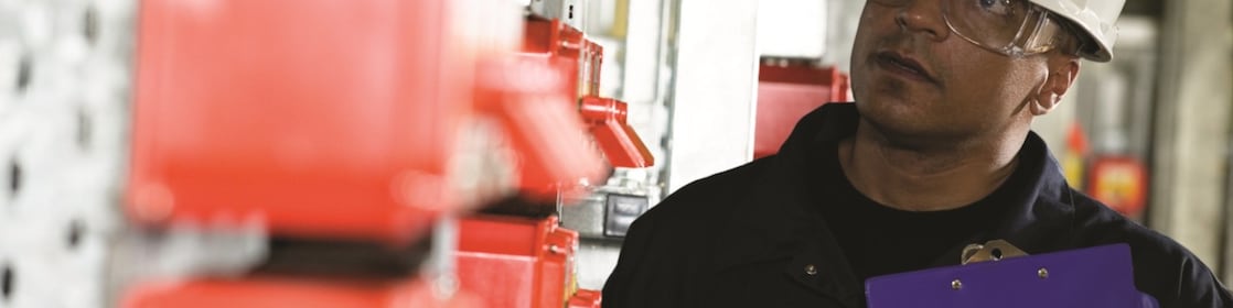 Arbeiter mit Schutzhelm auf einem Betriebsgelände