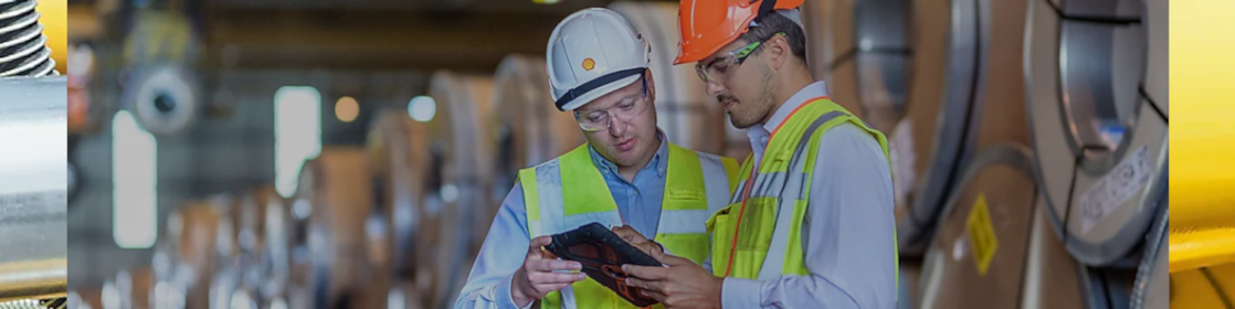 Two Shell employees studying a tablet in factory