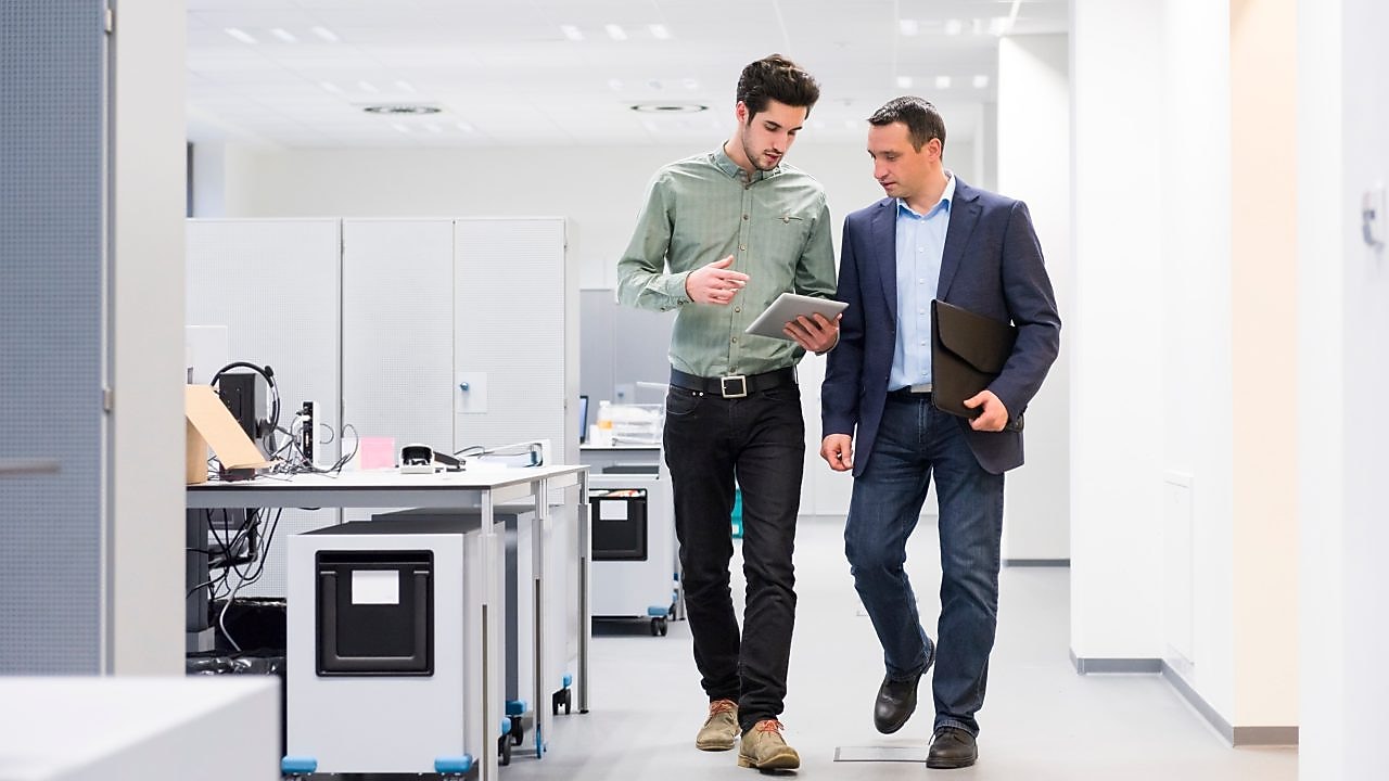 Shell Mitarbeiter berät einen Industriearbeiter vor Ort