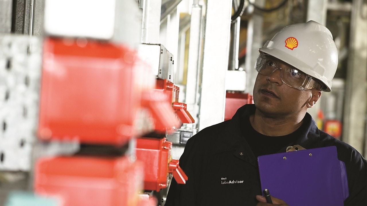 Shell Mitarbeiter berät einen Industriearbeiter vor Ort