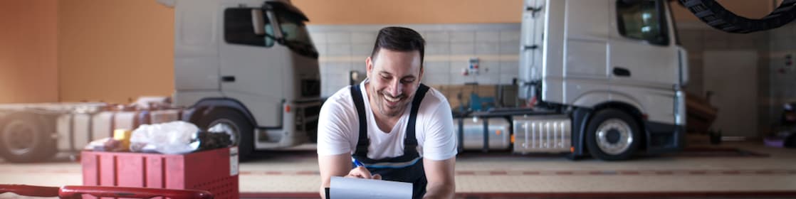 Lkw-Mechaniker füllt vor dem Service die erforderlichen Dokumente aus 