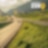 Auto fährt auf einer Schnellstraße durch grüne Landschaft mit Bergen im Hintergrund, Textaufschrift: "Accelerate to Zero".