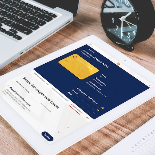 Ein Tablet liegt auf einem Tisch neben einem Laptop. Auf dem Tablet sind die Beschränkungsfunktionen des Shell Fleet Hub geöffnet.