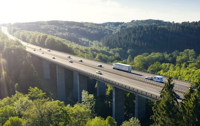 Eine Brücke führt über ein grünes Taal.