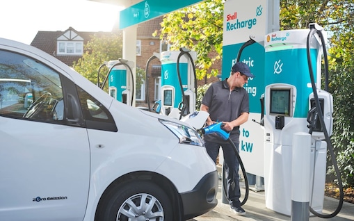 Ein Mann lädt seinen Van an einer Shell Recharge Ladesäule.