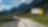 Auto fährt auf einer Schnellstraße durch grüne Landschaft mit Bergen im Hintergrund, Textaufschrift: "Accelerate to Zero".