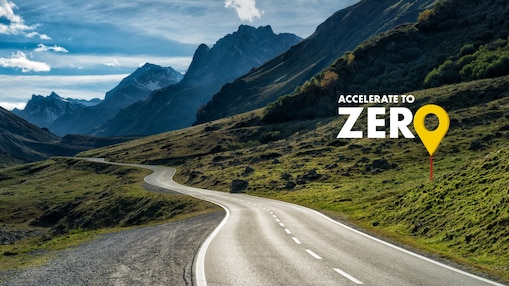 Auto fährt auf einer Schnellstraße durch grüne Landschaft mit Bergen im Hintergrund, Textaufschrift: "Accelerate to Zero".