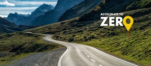 Auto fährt auf einer Schnellstraße durch grüne Landschaft mit Bergen im Hintergrund, Textaufschrift: "Accelerate to Zero".