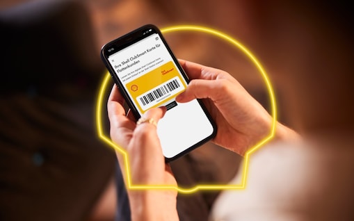 Jemand hält ein Smartphone mit der Shell App und Shell ClubSmart in der Hand.
