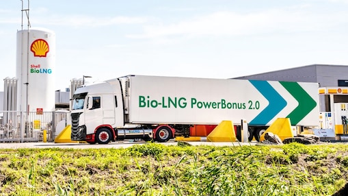 Ein LNG Lkw steht an eine LNG Station hinter einem Baum