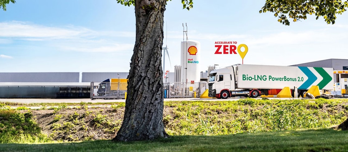 Ein LNG Lkw steht an eine LNG Station hinter einem Baum