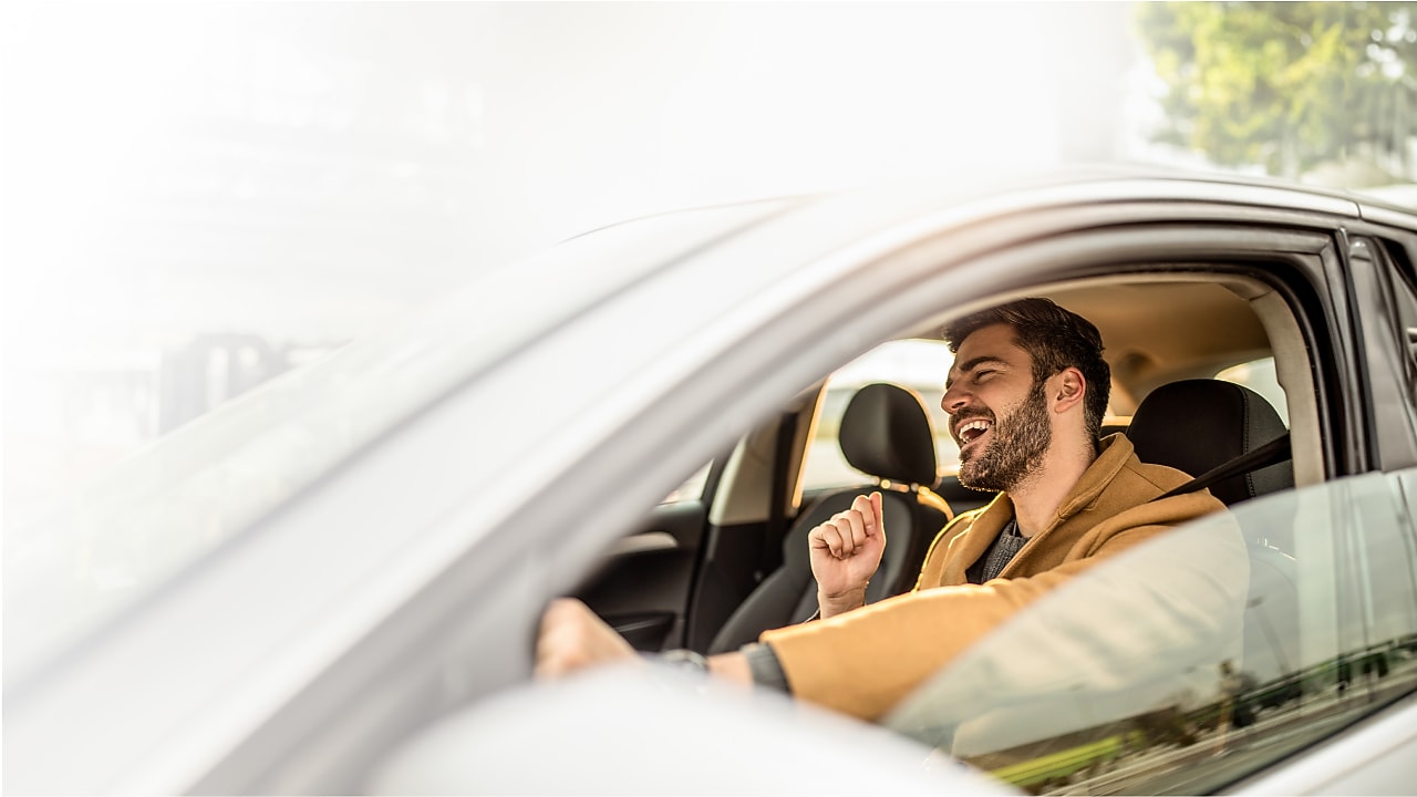 Ein Mann freut sich in seinem Auto