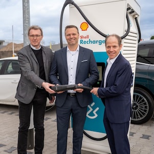 Mitarbeiter von SAP in Walldorf halten einen Shell Recharge Ladestecker